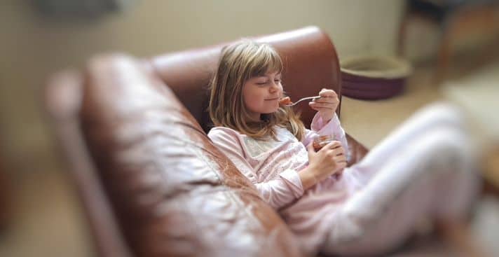 picture of young girl on couch blissfully enjoying unsweetened apple sauce UK