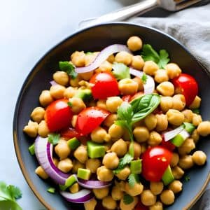 bowl of chickpea salad with red onion and tomato