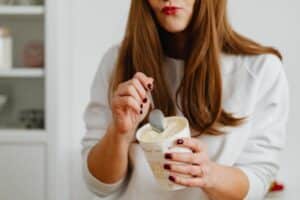 woman eating a tub of ice cream and sjow the correlation between food intolerance and gut health